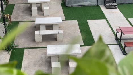 modern outdoor seating area with concrete tables and artificial turf
