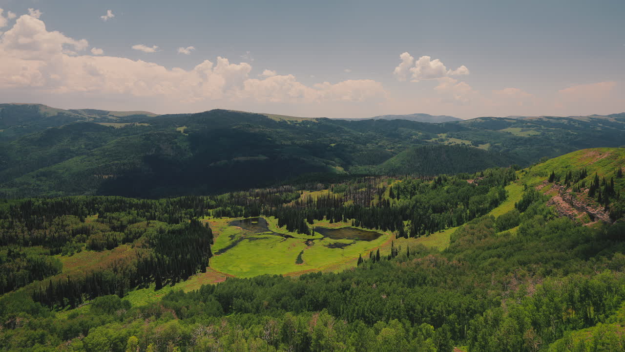 Lake Amidst Mountain Slopes With Dense Forest On A Sunny Day. Timelapse
