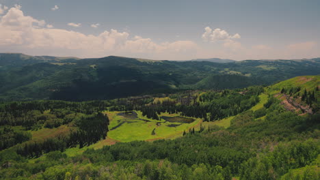 lake amidst mountain slopes with dense forest on a sunny day. timelapse