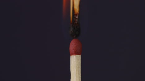 Hand-igniting-a-match-against-each-other-super-close-up-macro-shot-captured-on-black-background-in-slow-motion-at-60-fps