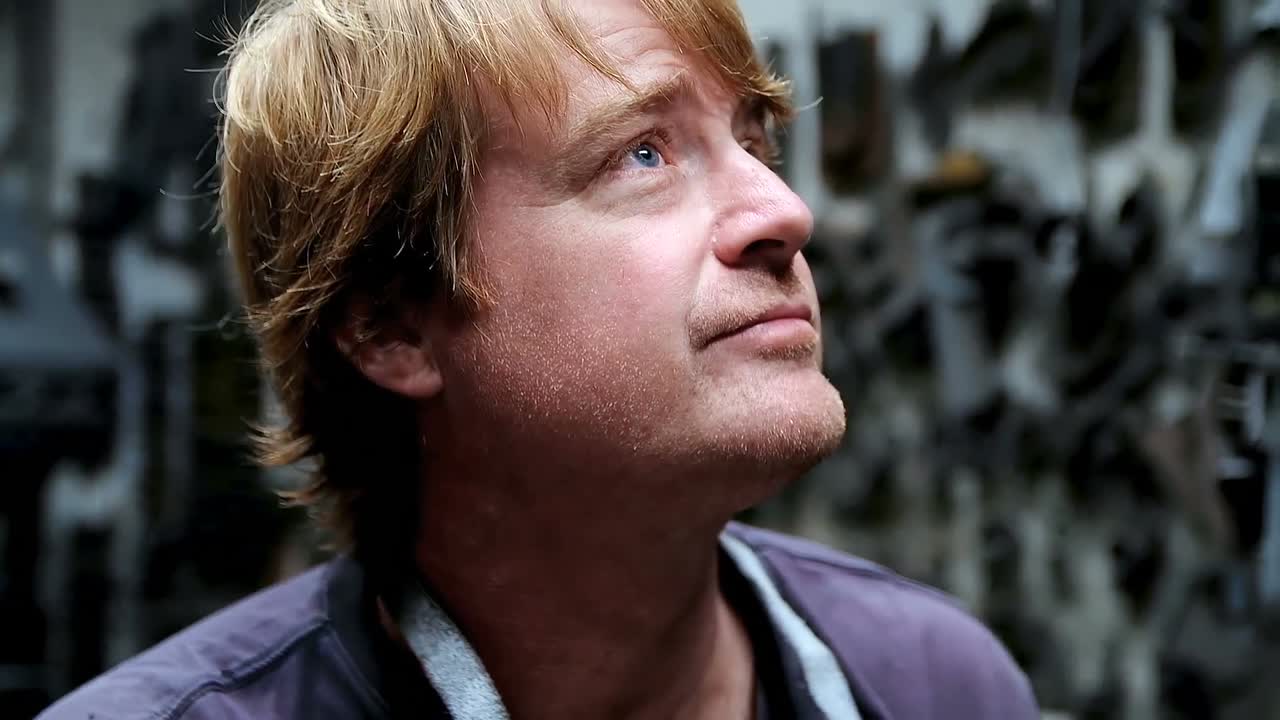 herrero fumando un cigarrillo en el taller 4k