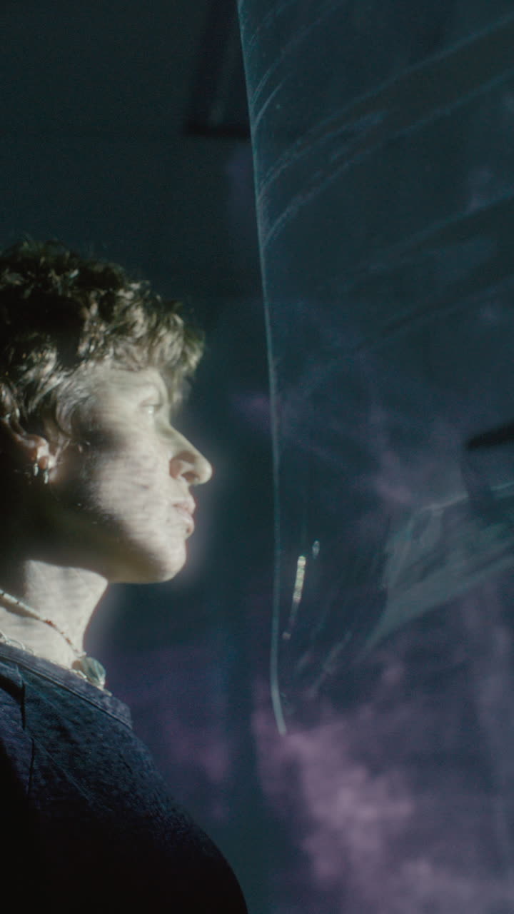 Young Woman Looking through Translucent Fabric with Projected Light