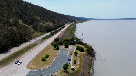 Paisaje-Aéreo-De-Drones-Vista-Escénica-Del-Parque-Junto-Al-Lago-George-Transporte-Automóviles-De-Carretera-En-La-Carretera-Federal-Goulburn-Canberra-Nsw-Ley-Viajes-Turismo-Australia-4k