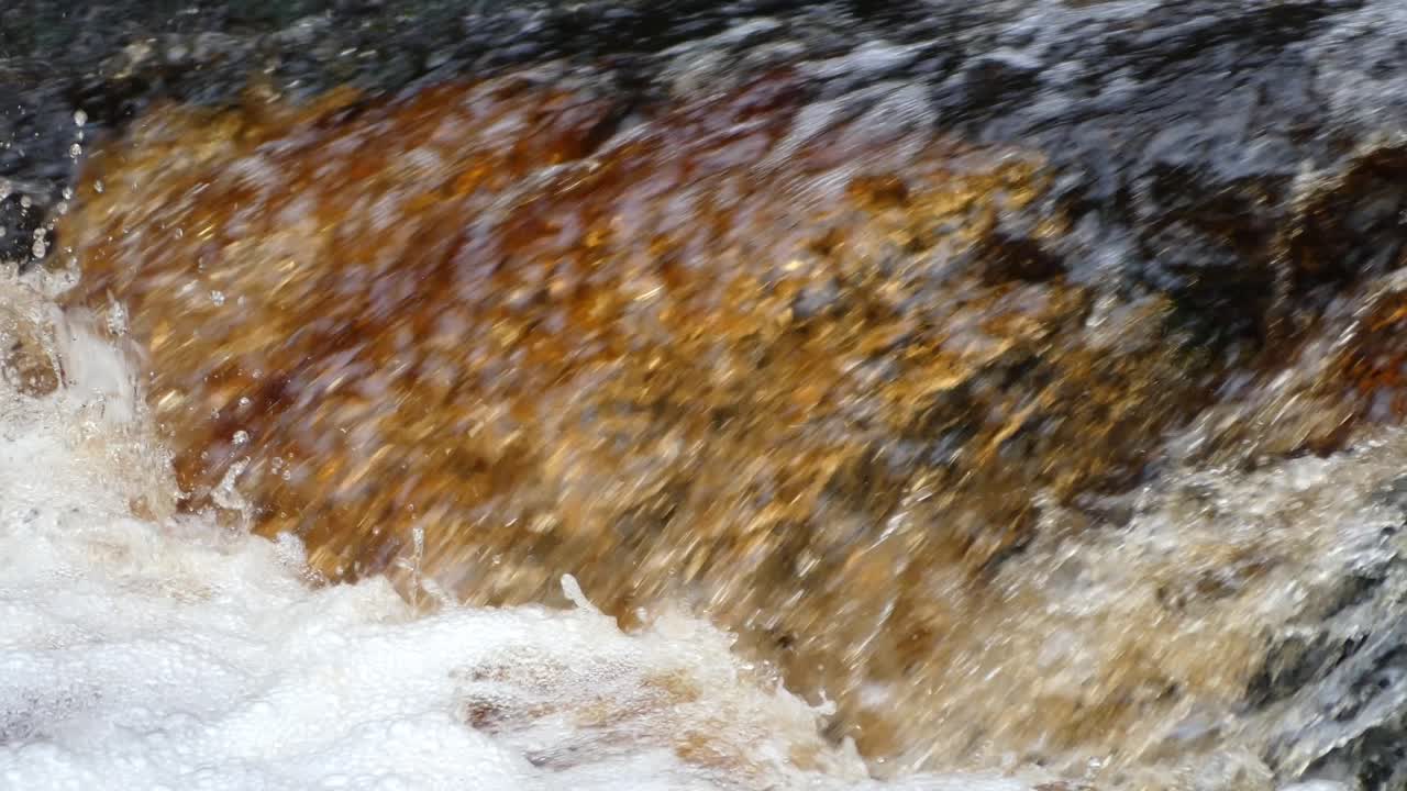 Friedliche Herbst-Winter-Waldlandschaft, ein langsamer Bach fließt über Felsen und bildet kleine Wasserfälle