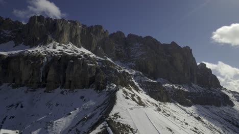 Drone-captures-Carezza-Ski-Resort-beneath-the-Dolomites,-featuring-the-Konig-Laurin-lift,-a-lively-slope-with-skiers,-and-the-scenic-backdrop-of-Road-di-Vael,-Dolomites,-and-Latemar-mountain-range