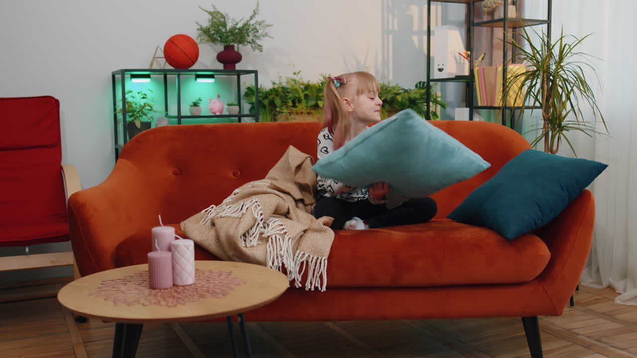 피곤하고 게으른 잠자는 어린아이 소파에 누워있는 소녀는 집에서 혼자 에너지 부족을 느니다.