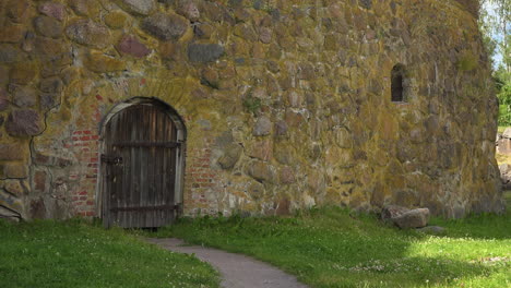 a front view of an ancient fortress made of stone with a wooden gate