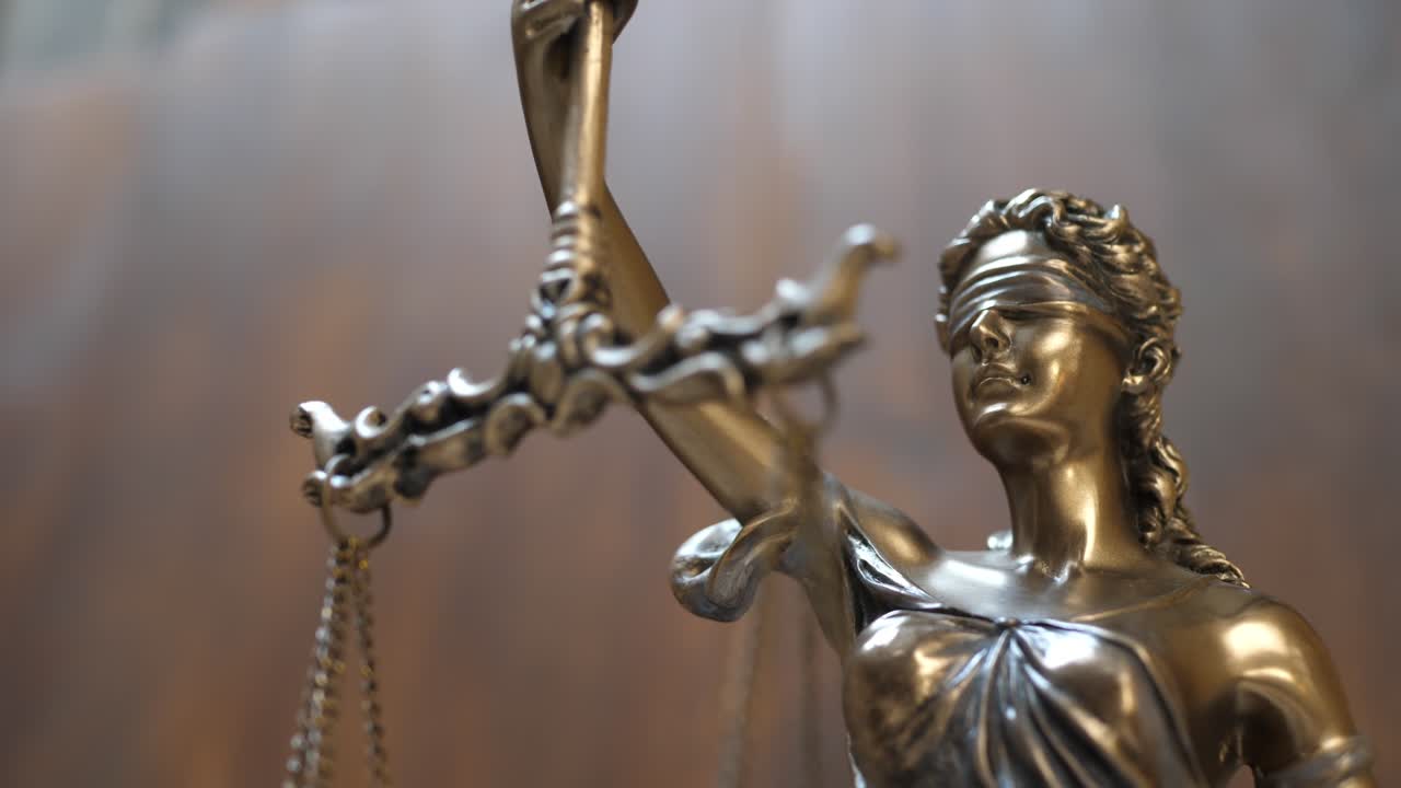 Close-up of blindfolded bronze Lady Justice with balance scales, captured in detail