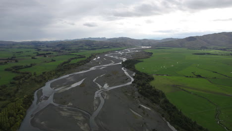 drone shot flying along the waiau river, cloudy evening in new zealand