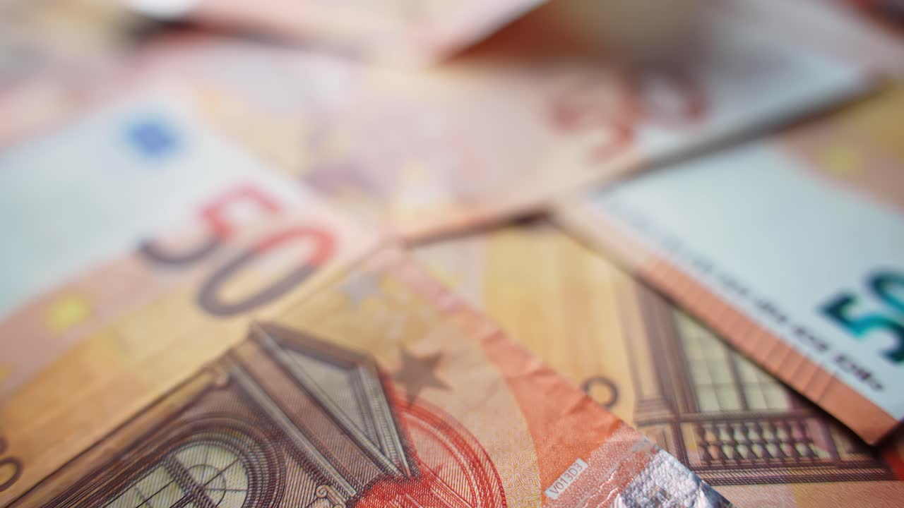 Nærbillede af en stak 50 eurosedler med blød bokeh og lav dybdeskarphed, ideel til visualiseringer om budgettering, betalinger, inflation, bankvæsen og privatøkonomi.