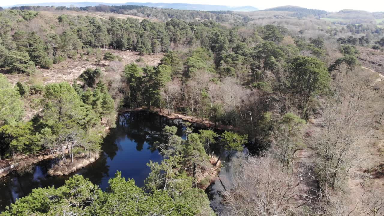 descenso aéreo disparado sobre piscinas de bystock rodeadas de árboles forestales en exmouth
