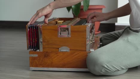 Indisches-Harmonium,-Musikinstrument,-Das-Von-Einem-Auf-Dem-Boden-Hockenden-Musiker-Manuell-Gepumpt-Wird