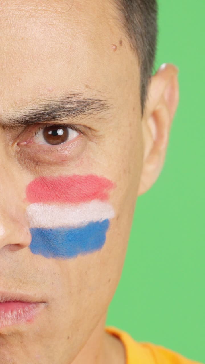Serious man with a dutch flag painted on the face