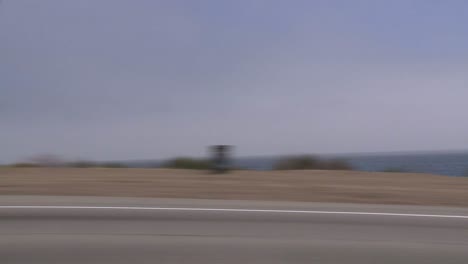 un automóvil viaja a lo largo de la autopista de la costa pacífica como se ve a través de la ventana lateral 3