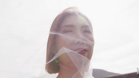 video of happy asian bride in veil smiling at outdoor wedding