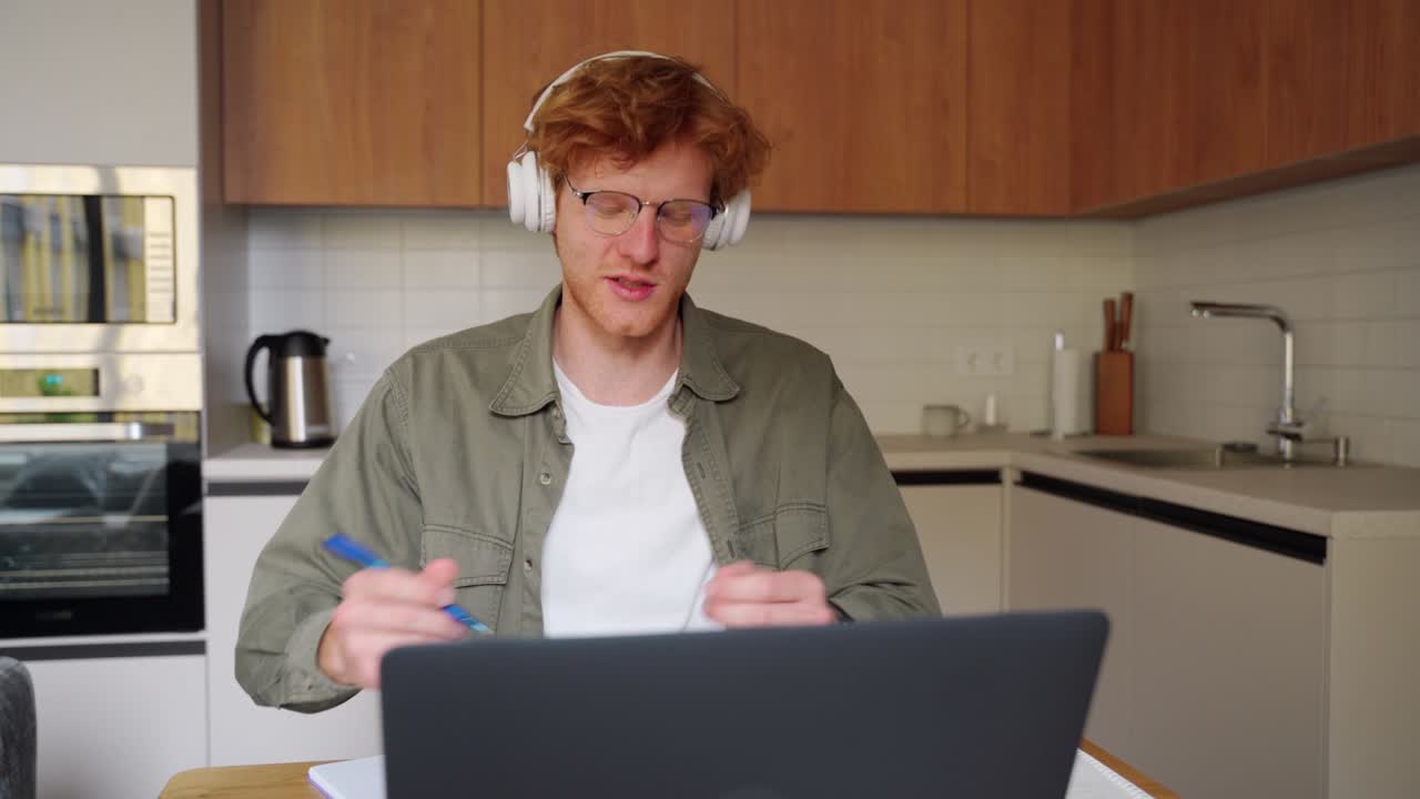 Young ginger irish man in headphones listen business tutor coach at webinar