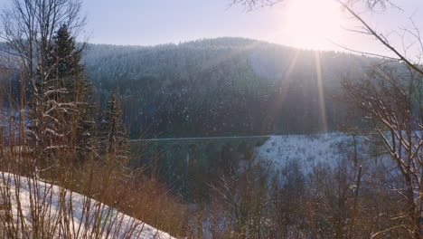 Tren-Pasando-Por-Un-Viaducto-En-Las-Montañas-En-La-Caída-De-Nieve,-Luz-Solar