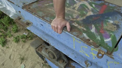 cultive a un hombre anónimo balanceándose en una construcción metálica mientras muestra el pino durante la práctica en la ciudad