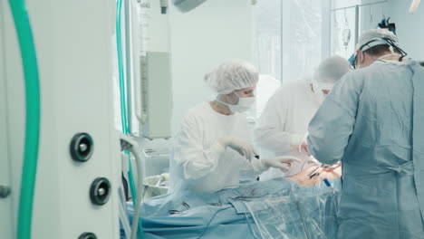 surgical team performs surgery in clinic. skilled medics in sterile uniform operate patient creating new pathway for blood flow in operating room