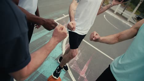 disparo en primer plano de jugadores de baloncesto jugando rock-paper-scissors para determinar el equipo que jugará la pelota primero