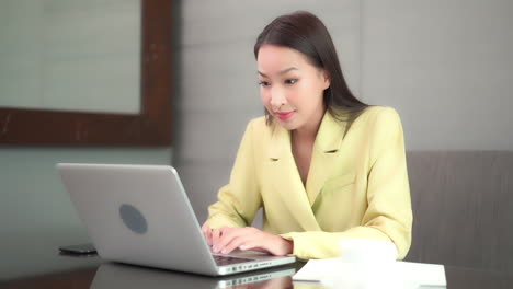 a beautiful young businesswoman works feverishly on her laptop