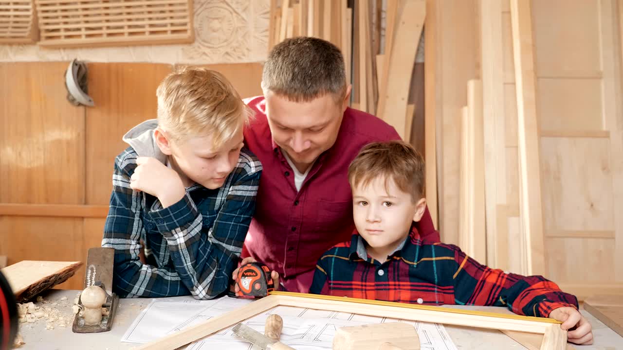 familia, carpintería, madera y concepto de la gente. el padre enseña a su hijo carpentería.