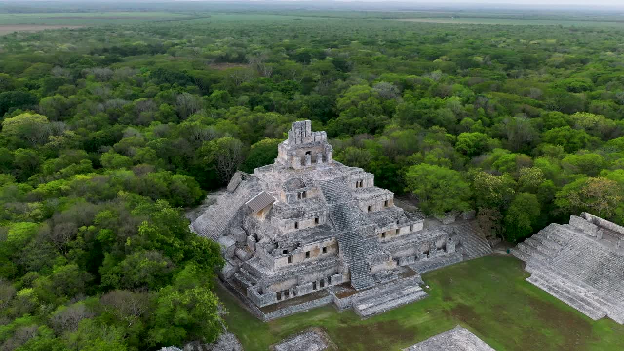 drone volando alrededor de ruinas mayas en medio de la jungla