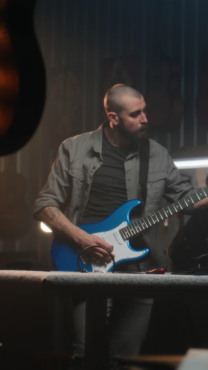 hombre tocando la guitarra eléctrica en un taller