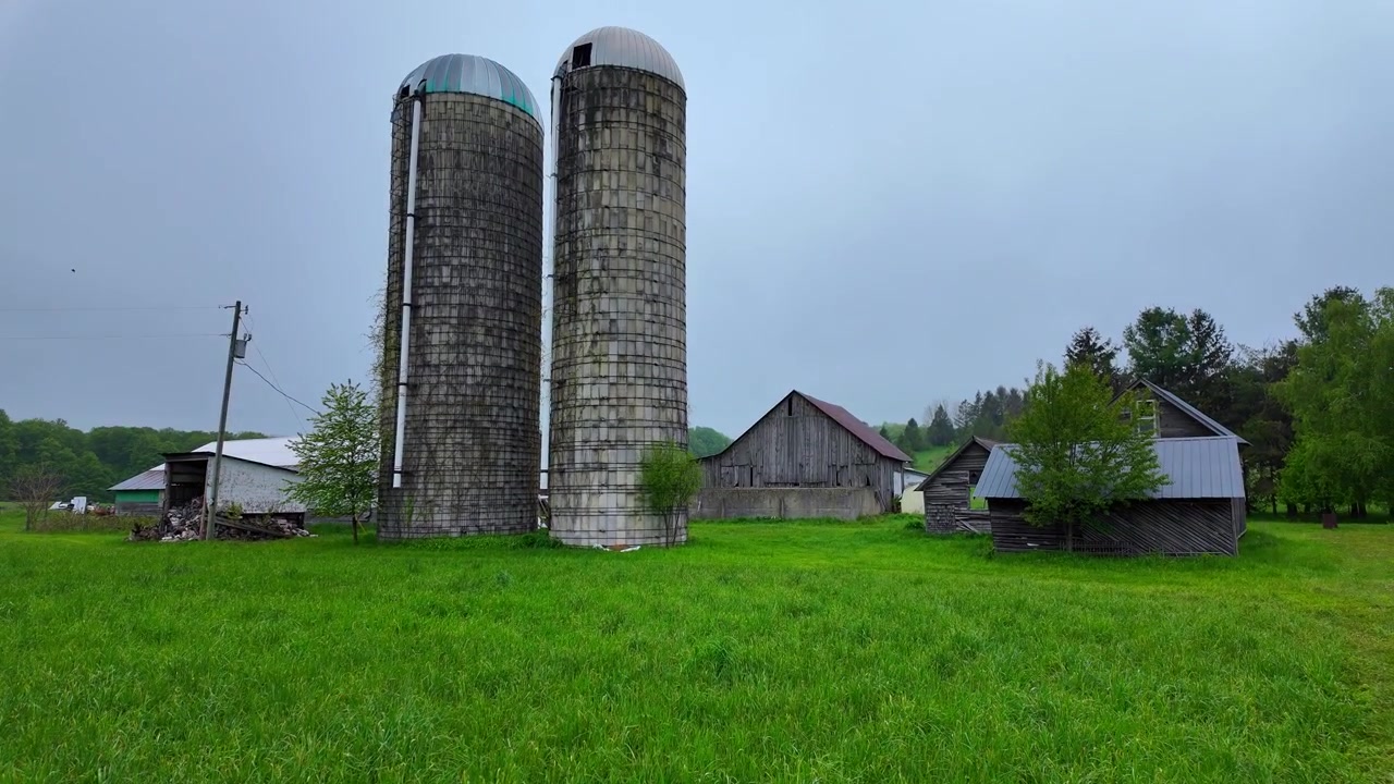 Gammel rustik lade og siloer, der dukker frem på en tåget morgen i Leelanau County, Michigan i det landlige Amerika