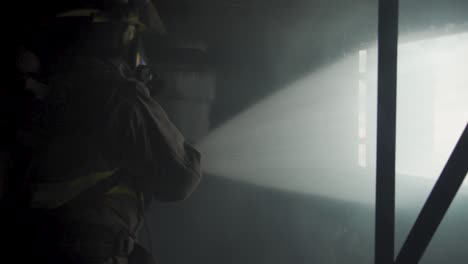 Water-spraying-from-hose-out-window-clears-smoke-from-burning-building