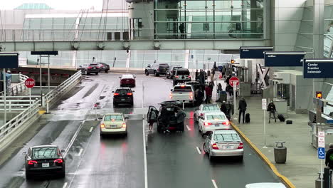 travelers putting luggage into vehicles after arriving into portland international airport, handheld view