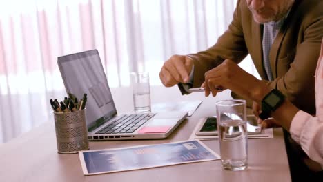 businesspeople discussing over laptop