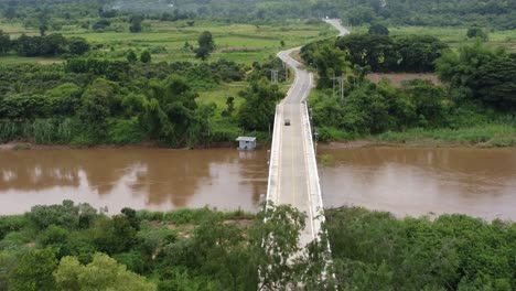 Ein-Einzelnes-Fahrzeug-Fährt-über-Eine-Brücke-Mit-Fluss-Darunter-Und-Auf-Eine-Landstraße