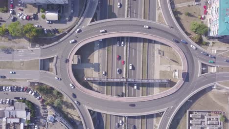Drehende-Luftaufnahme-Eines-Kreisverkehrs-Und-Einer-Autobahn-Mit-Verkehr-Und-Autos