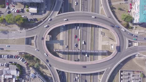 spinning aerial shot of roundabout and highway with traffic and cars