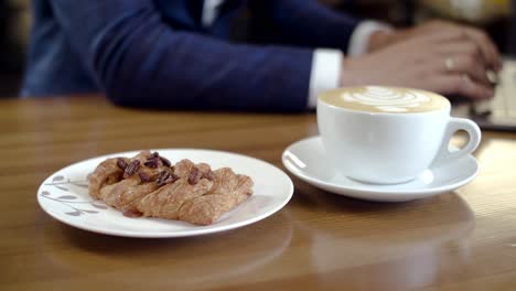 hombre de negocios disfrutando de café y pasteles en una cafetería