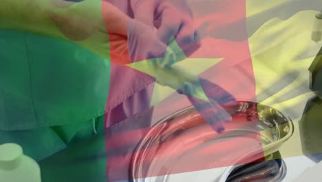 Animation-of-flag-of-cameroon-waving-over-surgeons-in-operating-theatre