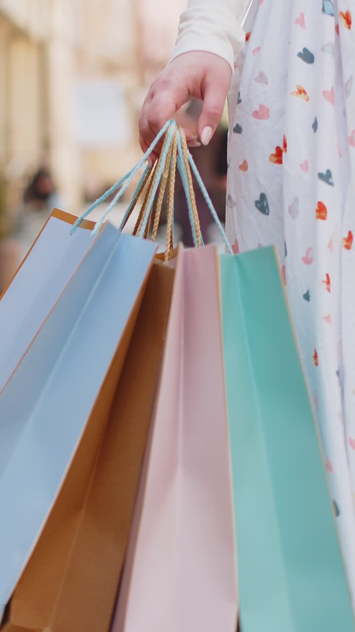 mujer anónima adicta a las compras consumidor después de la venta de compras con bolsas de colores con regalos al aire libre ciudad