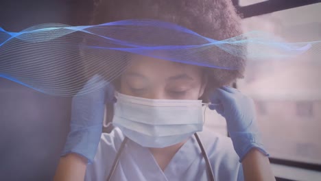 animación de manchas amarillas sobre una sonrisa de una doctora biracial que se quita la máscara