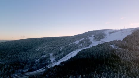 Tiro-Panorámico-Volando-Sobre-Un-Bosque-Nevado-En-Un-Paisaje-Montañoso-En-Manzaneda,-Galicia