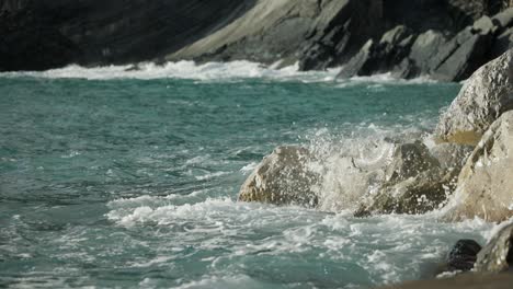 ocean waves breaking against the rocks and shoreline of italy