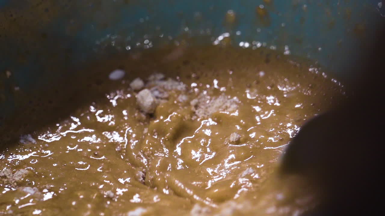 pastelero mezclando la masa de la torta en un bol a cámara lenta