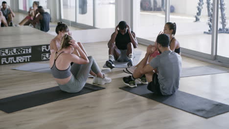 grupo diverso haciendo abdominales en un gimnasio
