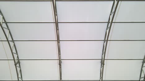 ceiling roof of arched metal steel structure inside hall aerial fly
