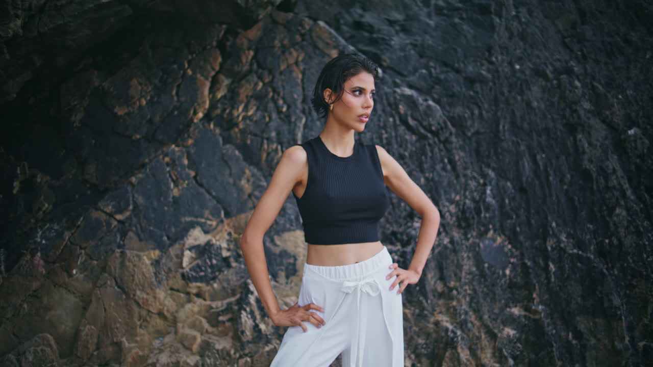 modelo de glamour posando al aire libre en los acantilados de la costa. atractiva morena elegante