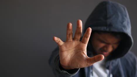 person in a hoodie with hand gesture