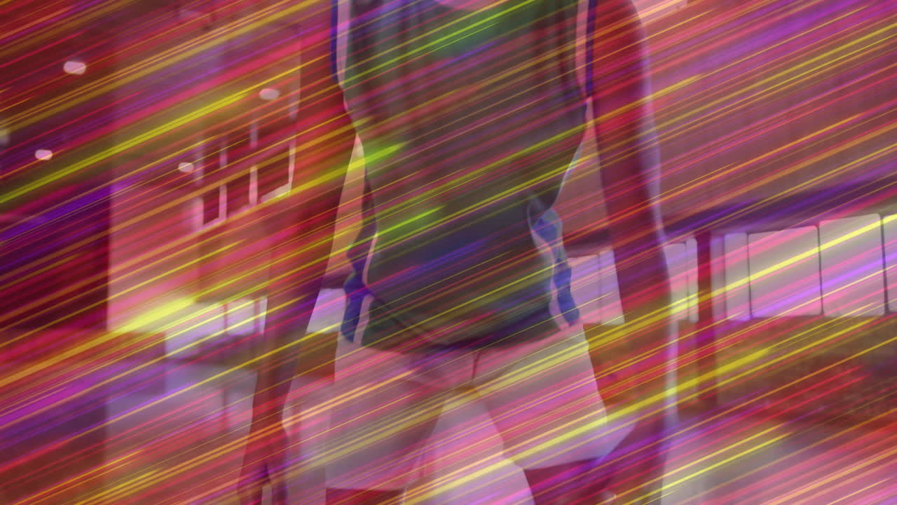 woman standing in design studio, with neon light streaks weaving across shiny panels