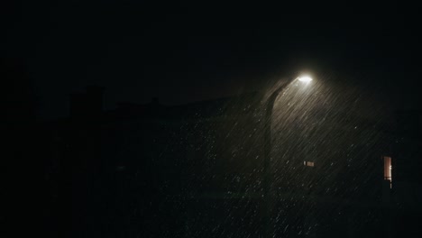street light in heavy rain and strong wind at night. thunderstorm with thunder lightning. static shot