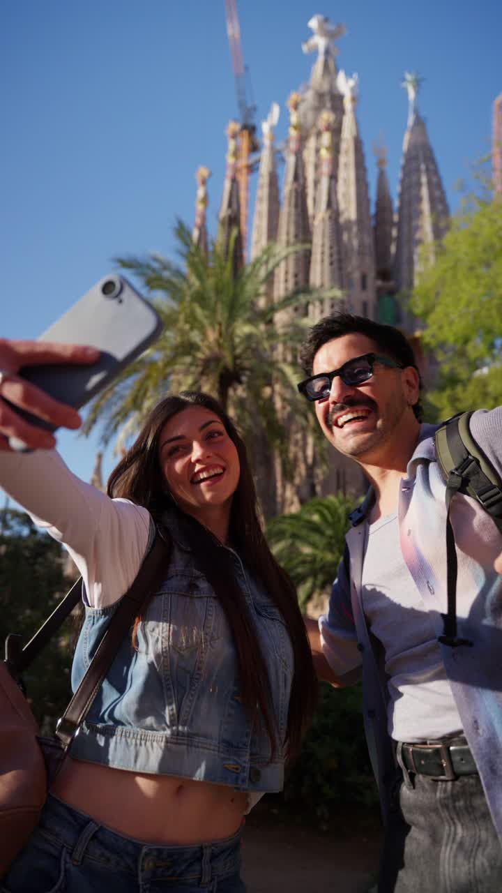 Pareja feliz tomándose un selfie frente a la Sagrada Familia.