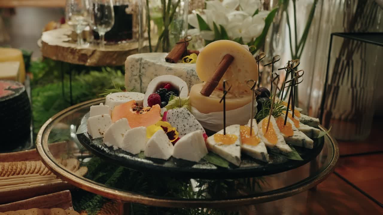 assorted fine cheeses with fruit and herbs on serving table